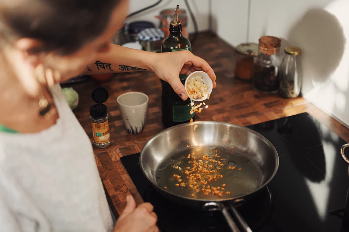 Spices being added to a stainless steel pan